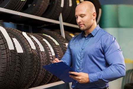 业务,维护和人的概念-在汽车维修服务或汽车商店有轮子轮胎和剪贴板的